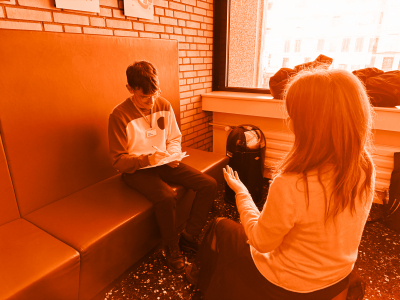 Foto von zwei Personen, die sich gegenüber sitzen und über ein Formular sprechen