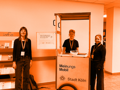 Foto von drei Personen, die um das MeinungsMobil stehen