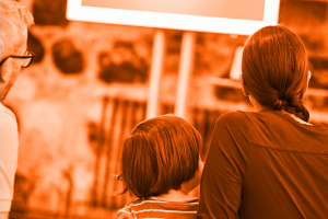 Foto von einer Familie, die vor einem Bildschirm sitzt